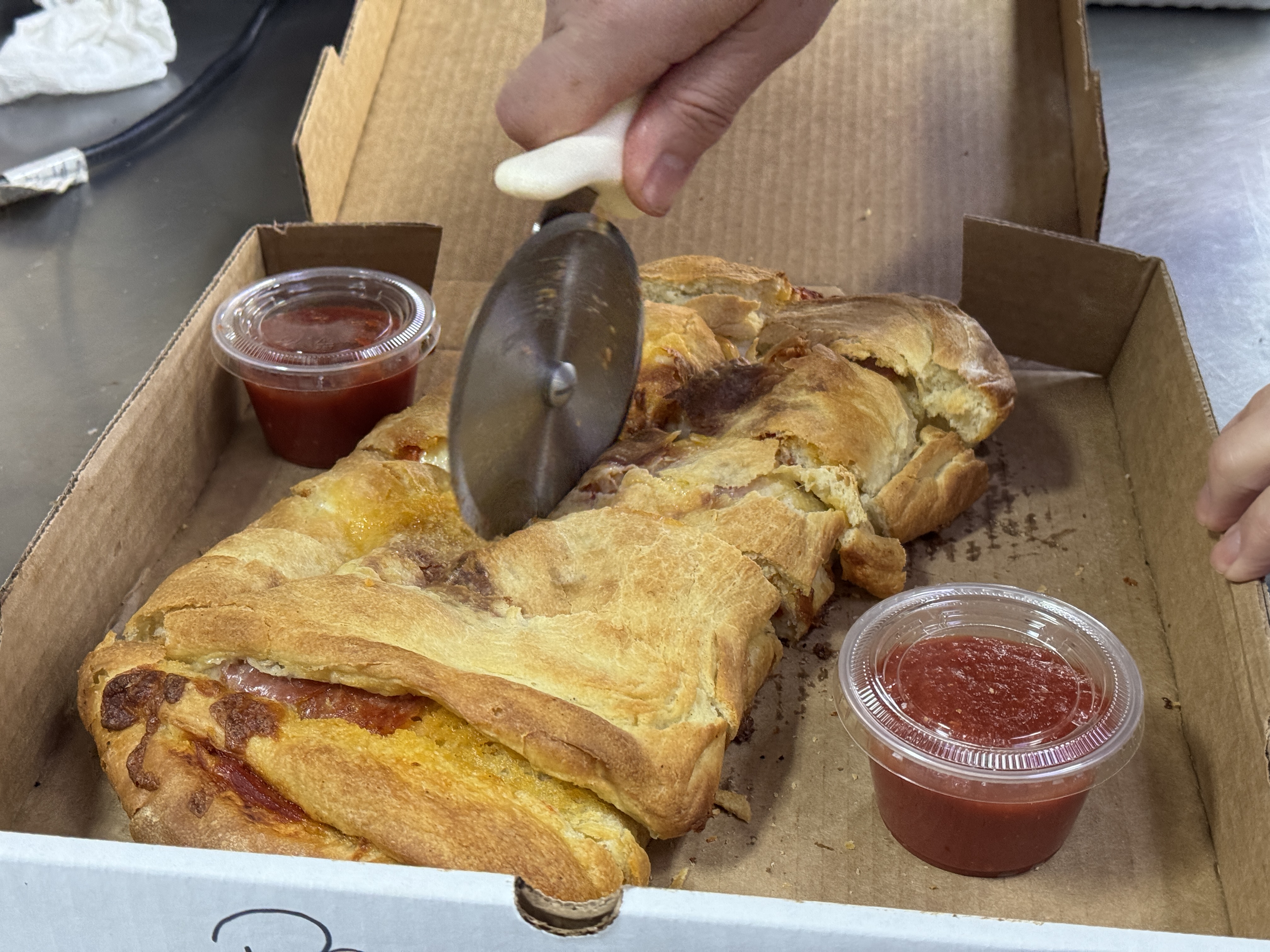Pepperoni roll being cut for pickup