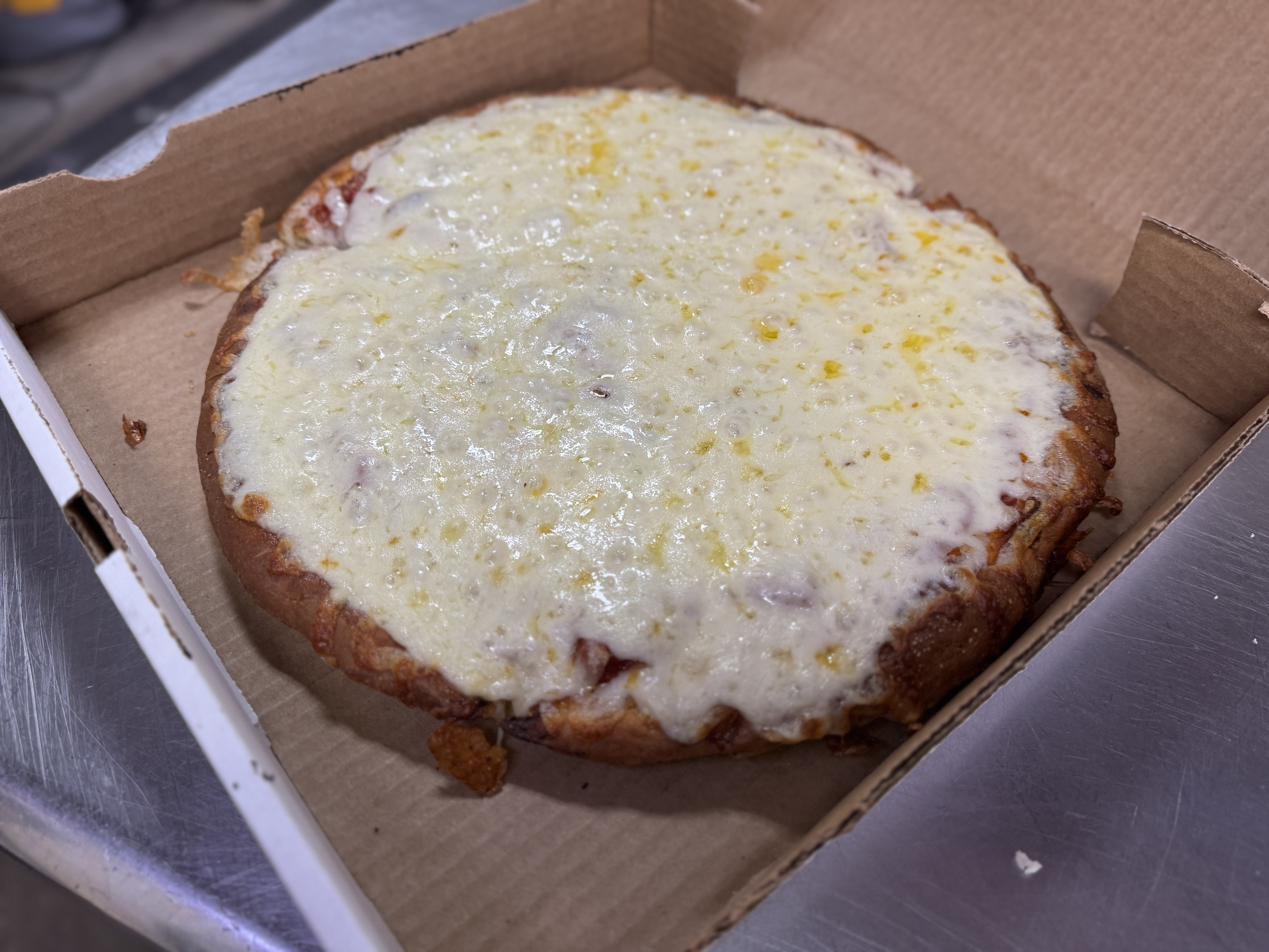 Fresh cheese pizza ready in an open takeout box