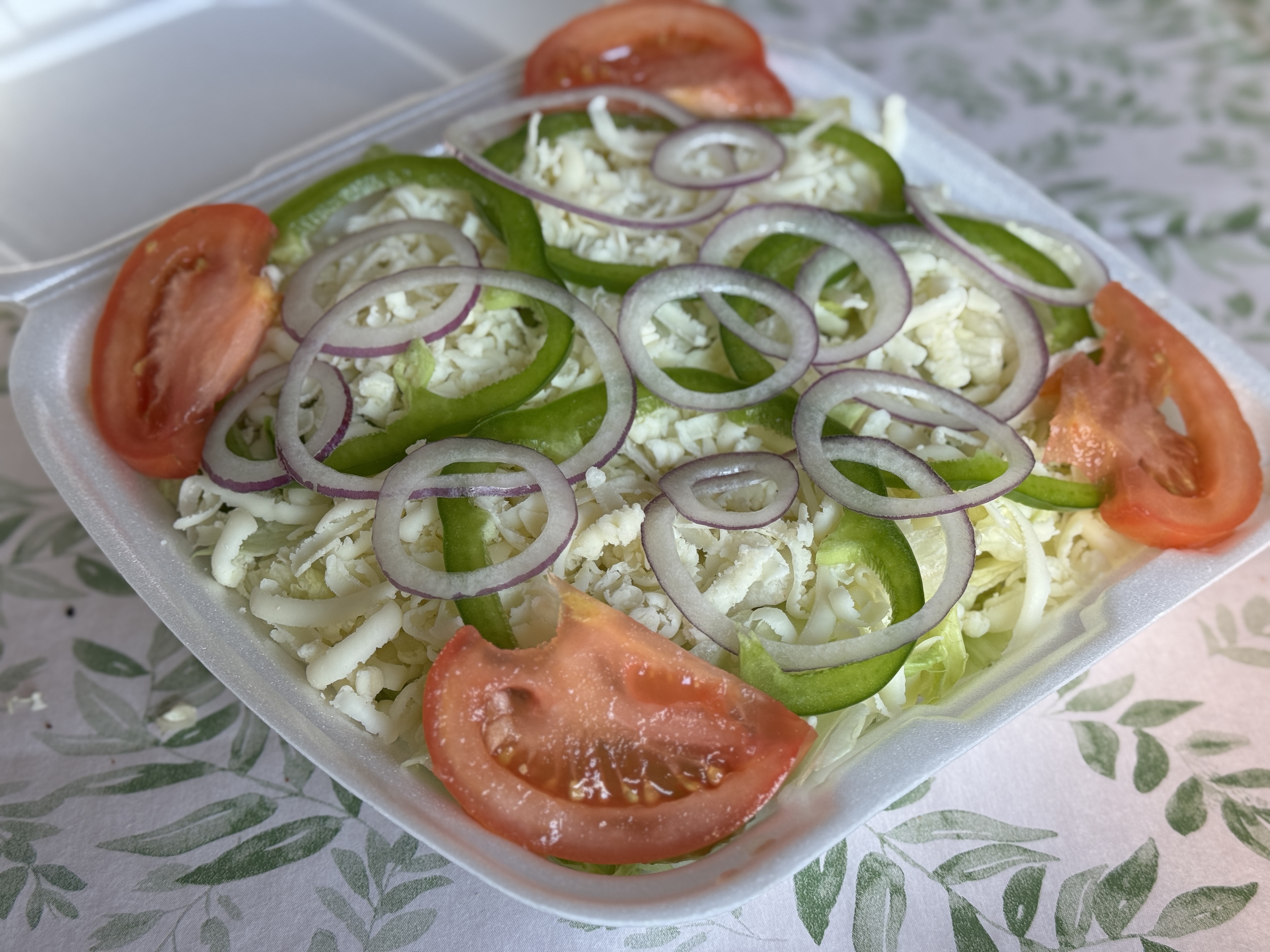 Focaccia sandwich with ham, tomato, onion, lettuce, and cheese