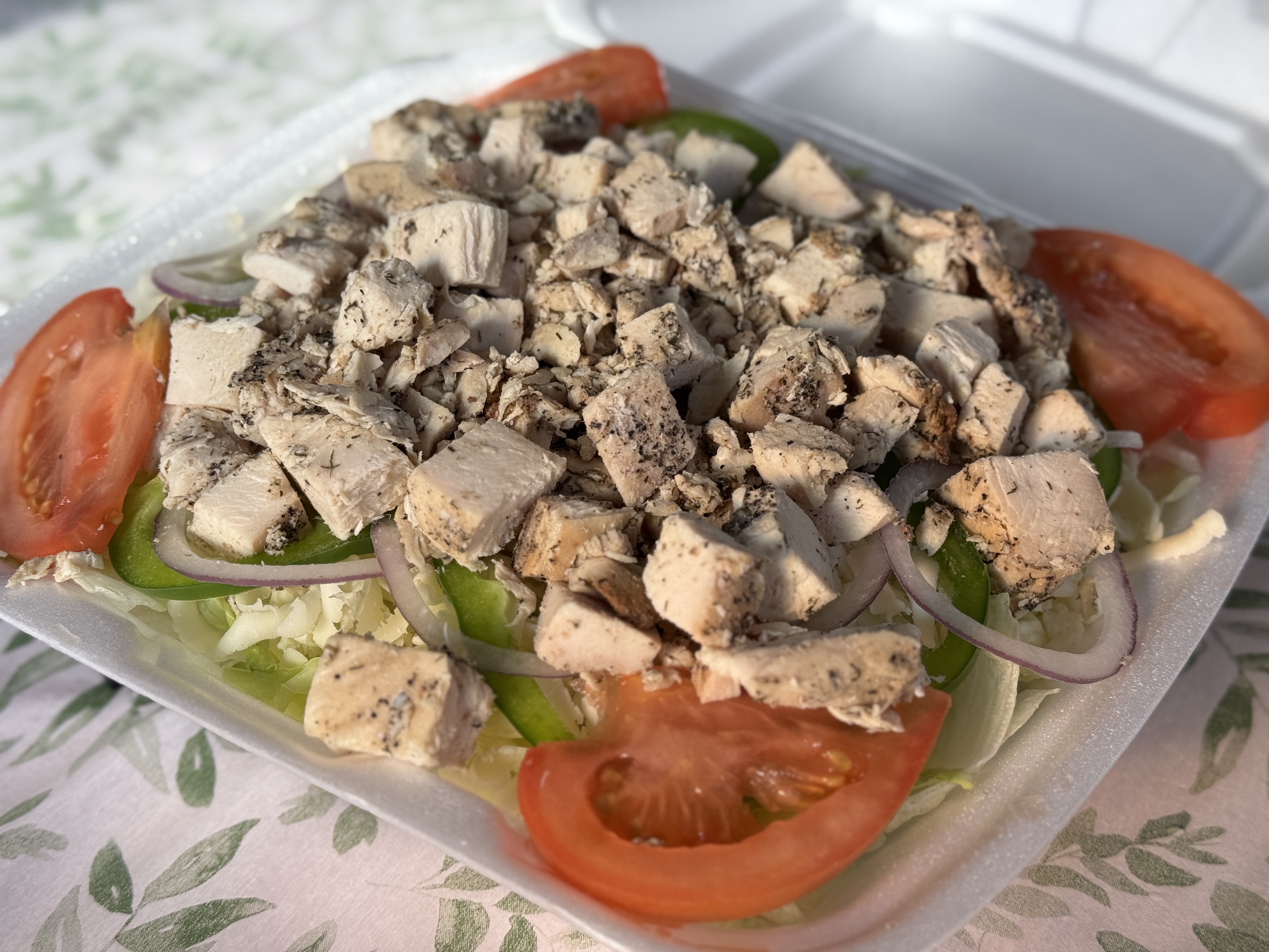 Chicken salad with tomatoes, onion, peppers, and provolone